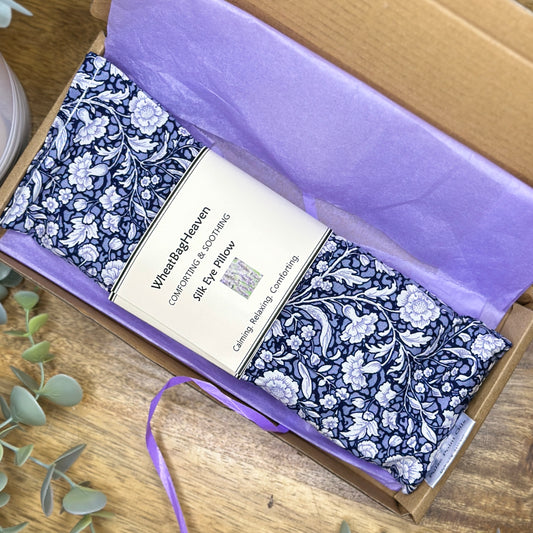 blue floral flaxseed eye pillow with lavender, wrapped in lilac tissue paper in its postal box from WheatBagHeaven