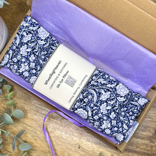 blue floral flaxseed eye pillow with lavender, wrapped in lilac tissue paper in its postal box from WheatBagHeaven 