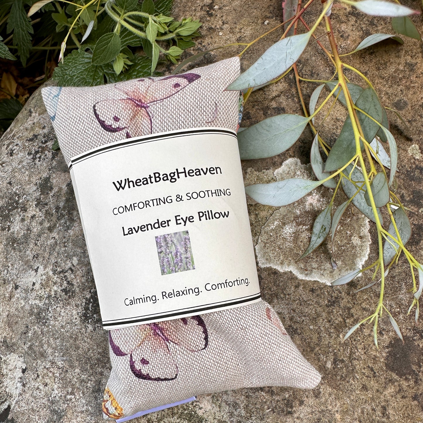 WheatBagHeaven eye pillow in a lovely butterfly print on a stone background with garden flowers
