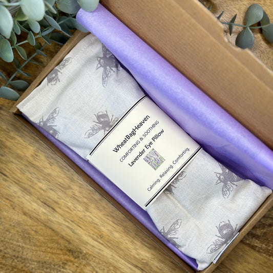 tissue wrapped grey bee printed eye pillow sleep mask, tied with ribbon in a letterbox postal box