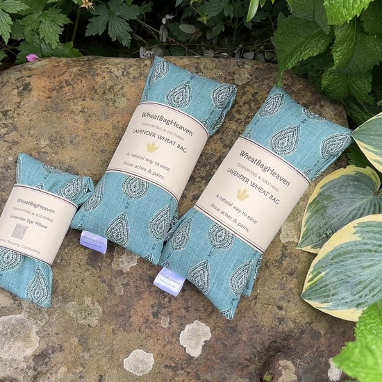 short video of WheatBagHeaven teal blue eye pillows and wheat bags with a garden backdrop 