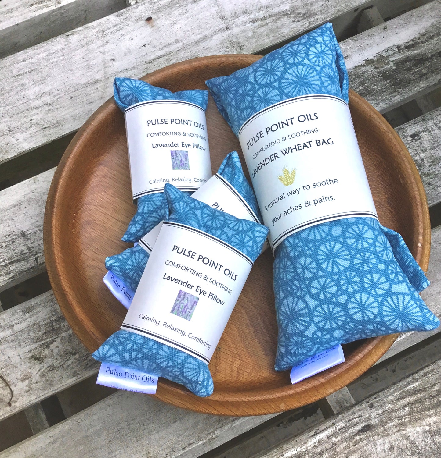 Holistic warming wheat bag body wrap in a beautiful teal fabricon a tray. Two teal lavender eye pillows