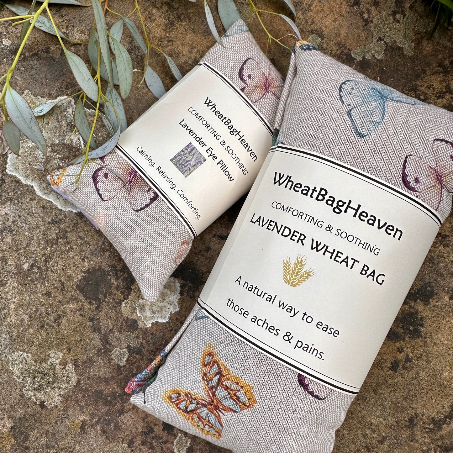 True Butterfly print eye pillow and matching wheat bag side by side on a garden stone