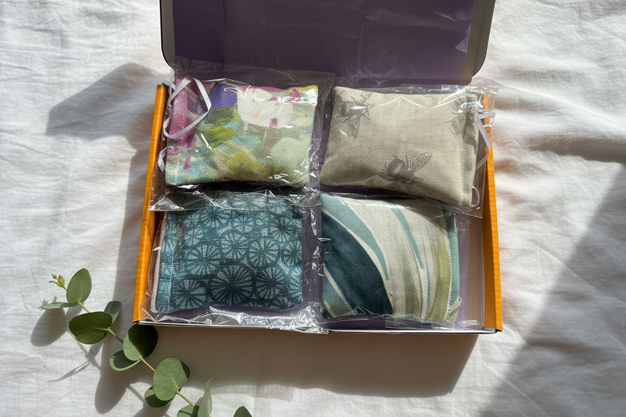 Packaged 4 pocket hugs  in a lilac tissue paper lined box. Each lavender sachet is individually packaged with clear wrap in a yellow postal box on a white background