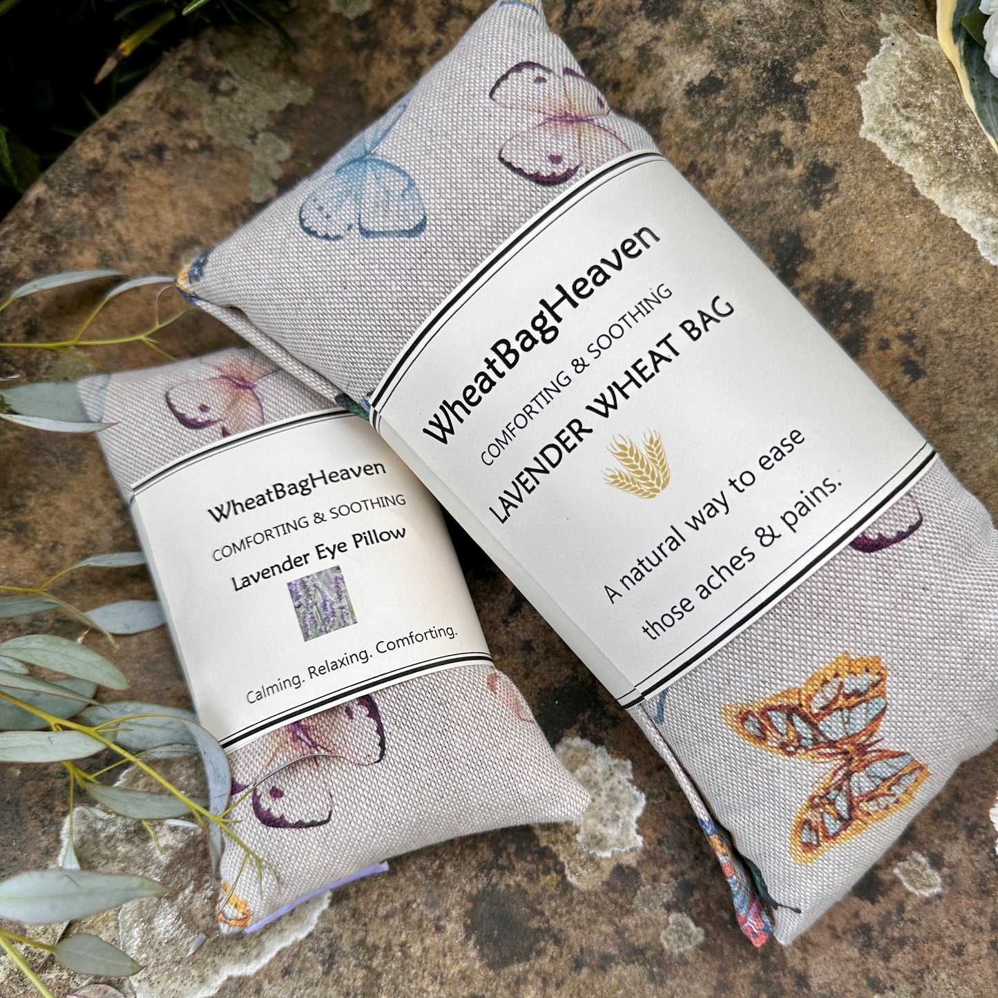 Lovely cotton wheat bag and eye pillow in a butterfly print on a beige background pictured in the garden of WheatBagHeaven 