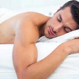 a man laid face down relaxing as the warmed lavender wheat bag soothes the lumber region