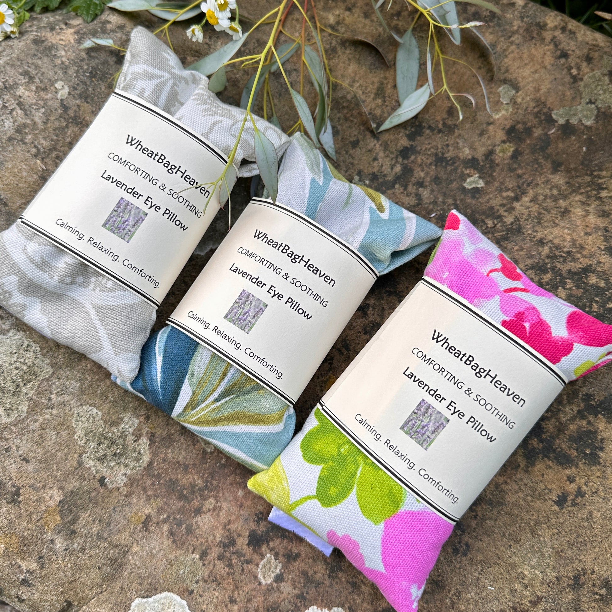 three lovely eye pillows from wheatbagheaven from left to right neutral beige botanical, Ventura exotic leaves in teals and blues, pink peonies, cotton fabric filled with flaxseed and a pinch of lavender 