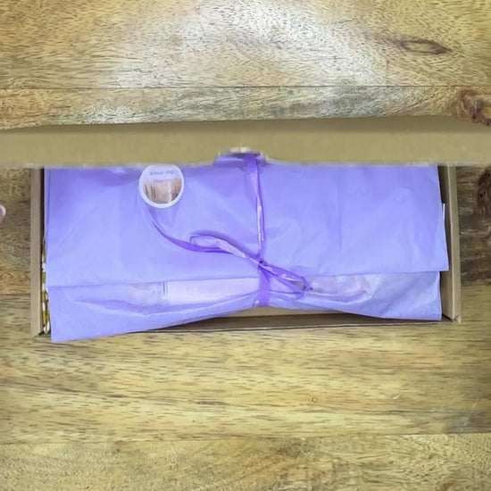 short video opening a box, unwrapping and revealing a beautiful silk yellow floral eye pillow from wheatbagheaven.com