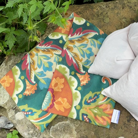 short video of WheatBagHeaven replacement wheat bag cover in a bright floral print alongside a plain covered lavender scented wheat bag