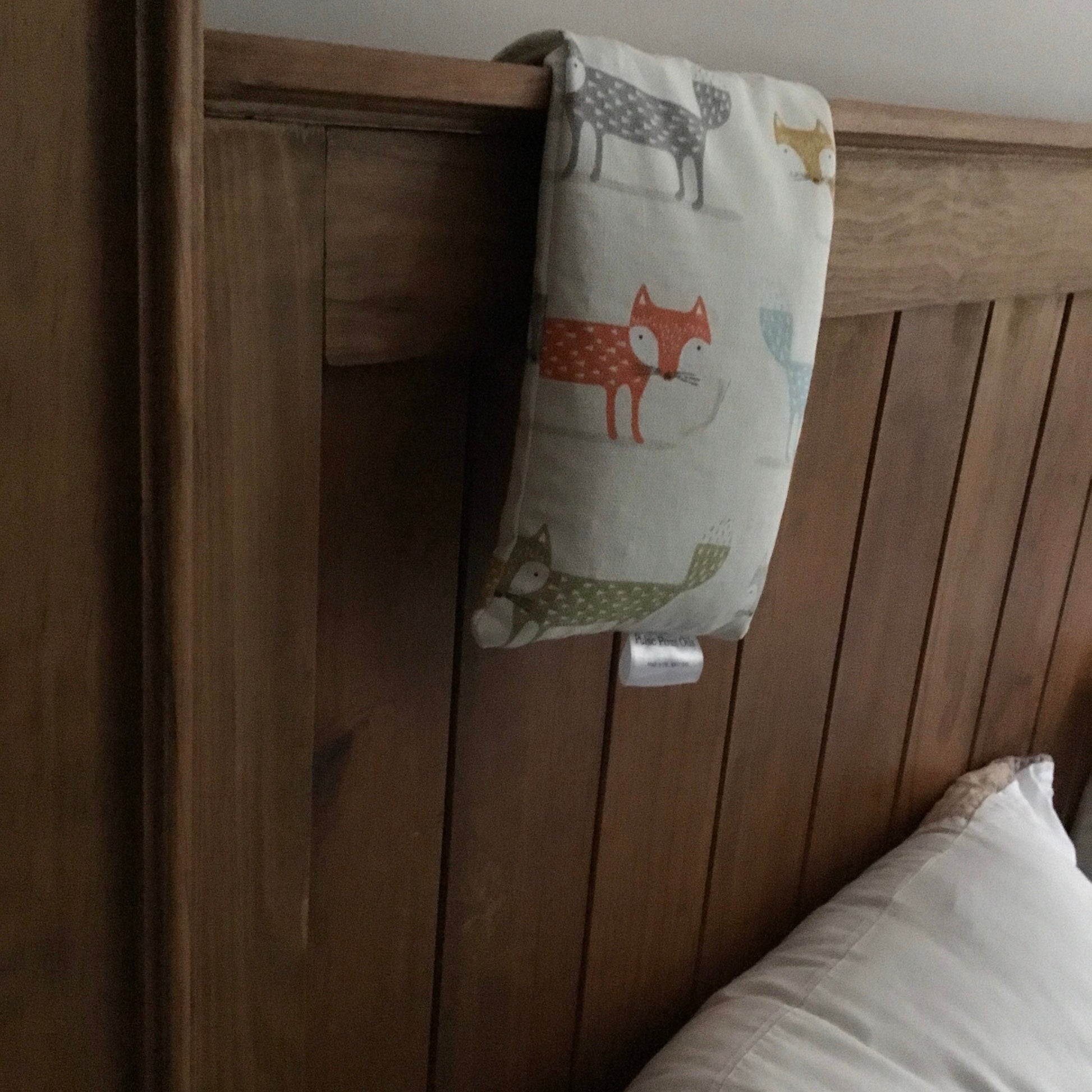 fox printed lavender wheat bag on a wooden headboard. 