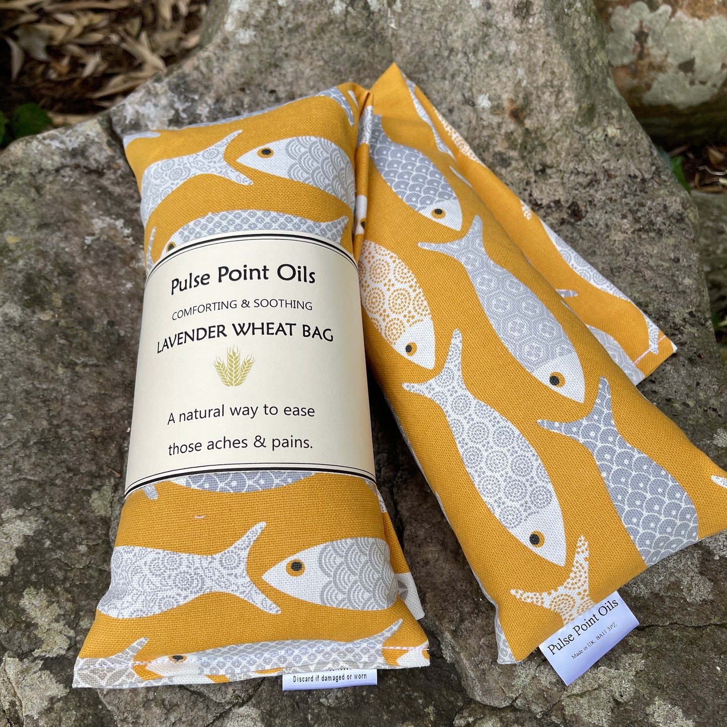 Long lavender scented wheat bags, in a yellow floral fish print.