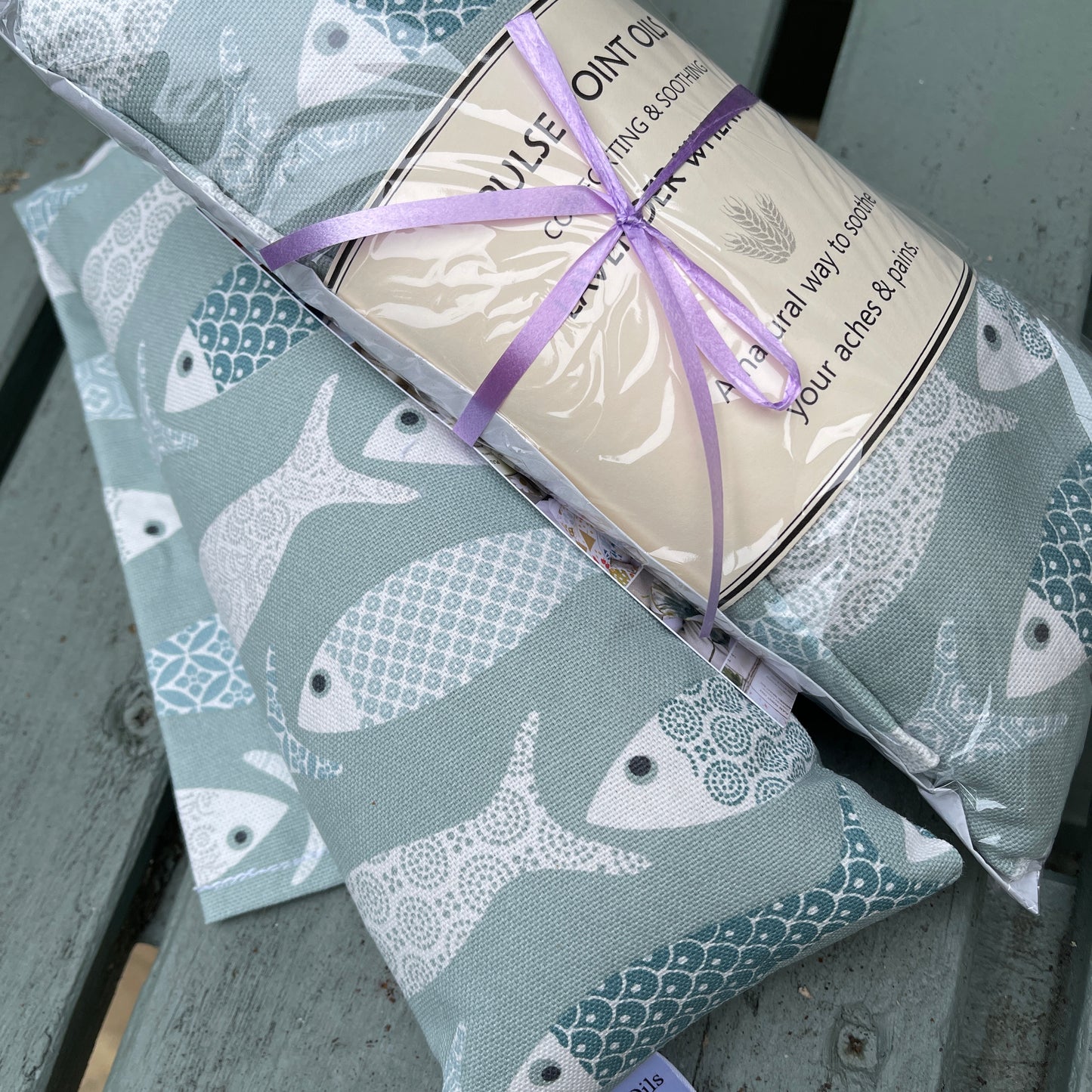 Blue long lavender scented wheat bags, in a floral fish print. Holistic heat pad for aches and pains. 